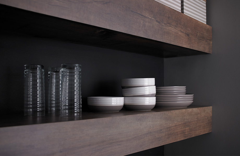 Dark brown woodgrain floating shelves holding dishes 